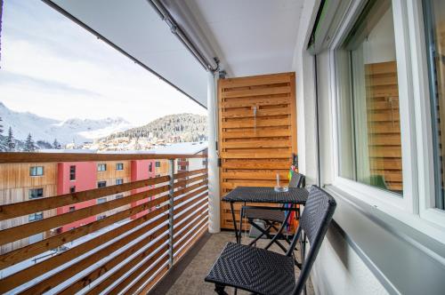 a balcony with a table and chairs and a window at Waldhof 1 - Waldhof 4 by Arosa Holiday in Arosa