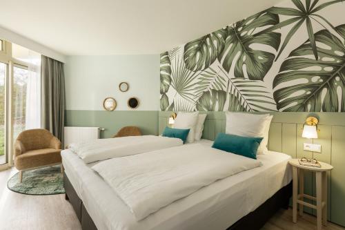 ビスピンゲンにあるHotel Bispinger Heide by Center Parcsのベッドルーム1室(ベッド2台付)が備わります。壁にはトロピカルな壁画が飾られています。