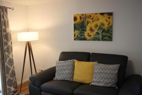 a living room with a couch and a painting at Ferienwohnungen Hasenknuck in Michelau