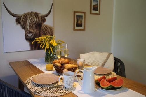 a table with a plate of fruit and a bull at Ferienwohnungen Hasenknuck in Michelau