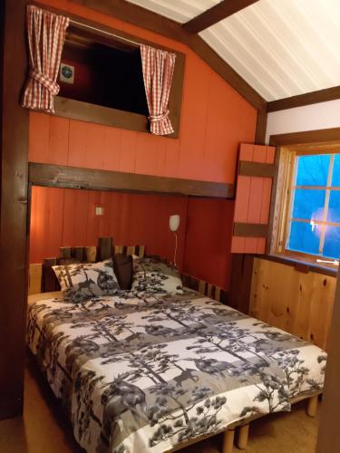 a bedroom with a bed in a room with red walls at Mieps Huset Dalarna Holiday in Kullen