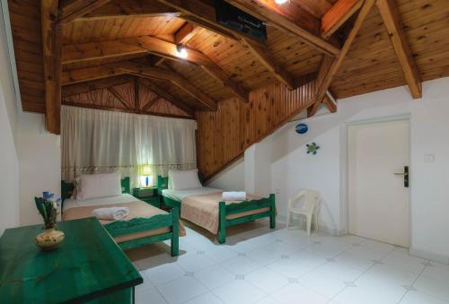 a bedroom with two beds and a wooden ceiling at Sofia - Yiota Studios & Apartments in Tsilivi