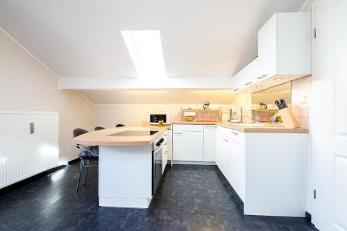 a kitchen with white cabinets and a wooden counter top at Lichtblick in Farchant
