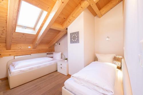 2 Betten in einem Zimmer mit Holzdecken in der Unterkunft Bergluft in Garmisch-Partenkirchen