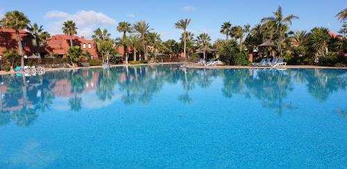 una grande piscina con acqua blu in un resort di Tamarindo I piscinas de agua salada a Corralejo