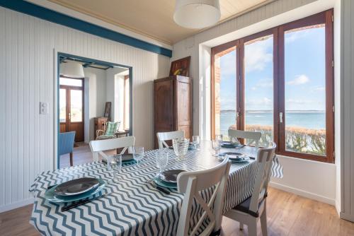 une salle à manger avec une table et des chaises avec vue sur l'océan dans l'établissement Villa des Roches - vue mer exceptionnelle, à Clohars-Carnoët