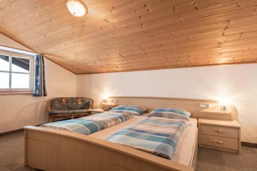 a bedroom with a large bed with a wooden ceiling at Ladinser Hof Sattelkammer in Castelrotto