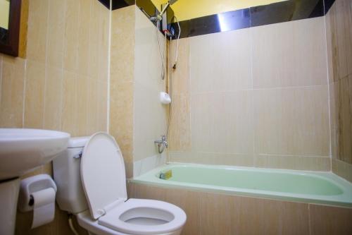 a bathroom with a toilet and a bath tub at SEACOAST HOTEL AND RESORTS in Mactan