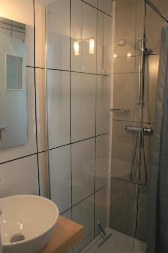 a bathroom with a glass shower and a sink at escapade en mer in Ault