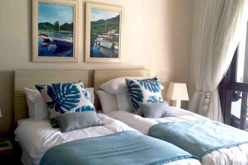 a bedroom with two beds with pillows on them at Maison L'Amirale by Simply-Seychelles in Eden Island