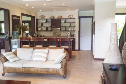 a living room with a couch and a dining room at Maison L'Amirale by Simply-Seychelles in Eden Island