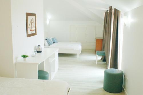 Habitación blanca con cama, escritorio y habitación en Hotel Baleal Spot, en Baleal