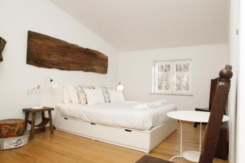 1 dormitorio con cama blanca y mesa en Cushy Apartment with garden in Estoril en Estoril