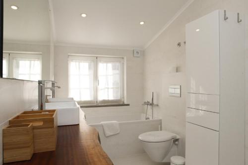 a bathroom with a tub and a toilet and a sink at Cushy Apartment with garden in Estoril in Estoril