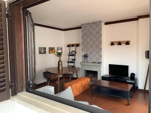a living room with a table and a fireplace at FLH Cascais Charming Old Town in Cascais