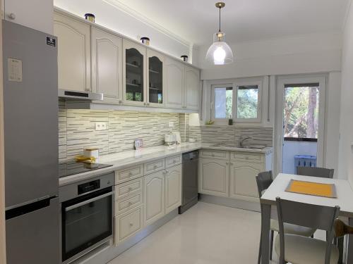 a kitchen with white cabinets and a table in it at FLH Cascais Posh Apartment in Cascais