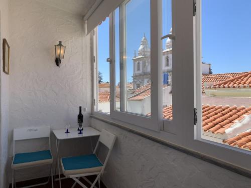 a balcony with a table and two chairs and a window at Relaxing apartment in the heart of Cascais in Cascais
