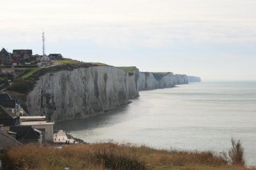 a large cliff next to the ocean with houses at escapade en mer in Ault