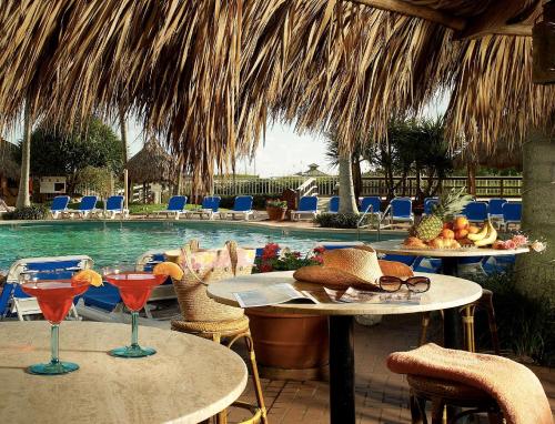 a pool with tables and chairs with drinks on them at Palm Beach Shores Resort and Vacation Villas in Palm Beach Shores
