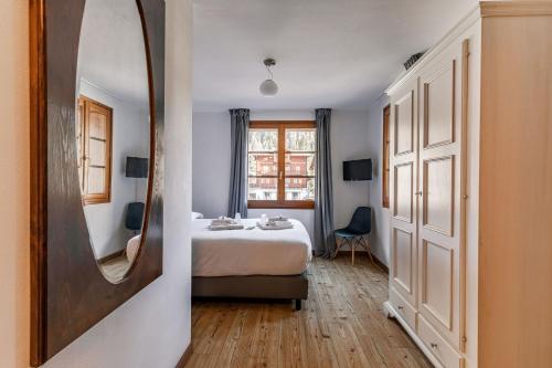 マクニャーガにあるHotel Dufourのベッドルーム(ベッド1台、大きな鏡付)