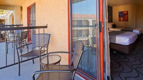 a balcony with chairs and a bed and a bedroom at Best Western Plus Heritage Inn in Stockton