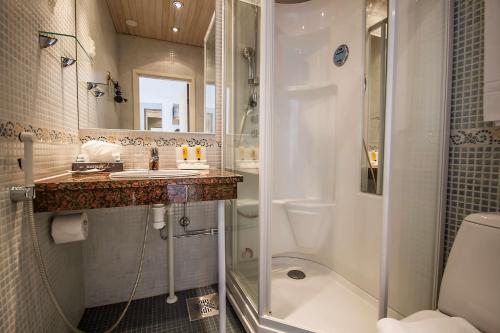 a bathroom with a shower and a sink and a toilet at Best Western Hotel Apollo in Oulu