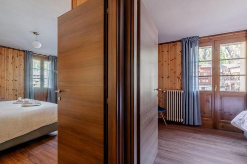 a bedroom with a bed and a wooden door at Hotel Dufour in Macugnaga