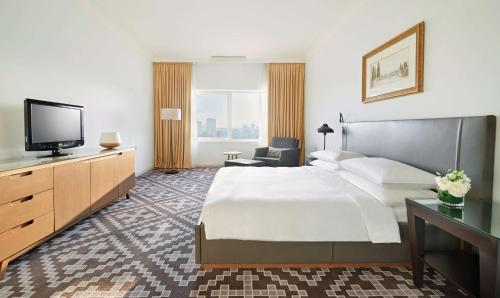 a hotel room with a bed and a flat screen tv at Hyatt Regency Baku in Baku