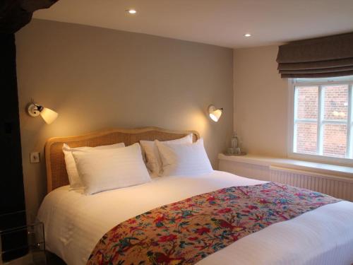 sypialnia z dużym łóżkiem z białą pościelą i poduszkami w obiekcie The Ship Inn w mieście Rye