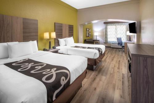 een hotelkamer met 2 bedden en een bureau bij La Quinta by Wyndham Atlanta Stockbridge in Stockbridge
