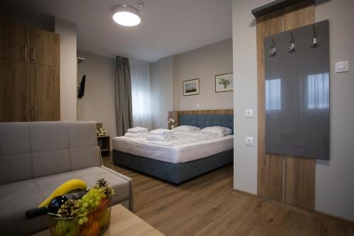 ein Hotelzimmer mit einem Bett und einem Sofa in der Unterkunft AquaSun Family Hotel in Sandanski