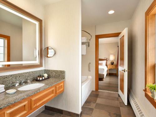 a bathroom with a sink, mirror, and toilet at Fairmont Jasper Park Lodge in Jasper