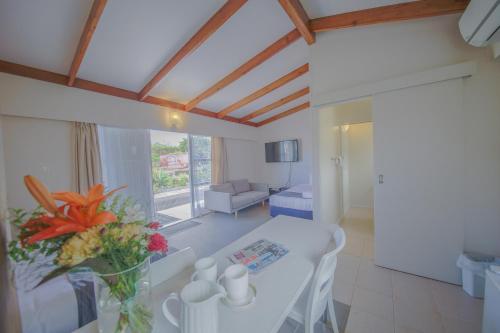 a living room with a white table and a vase of flowers at Sylvia Park Motel in Auckland