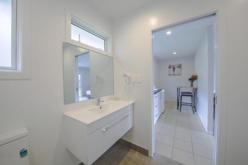 a white bathroom with a sink and a mirror at Sylvia Park Motel in Auckland