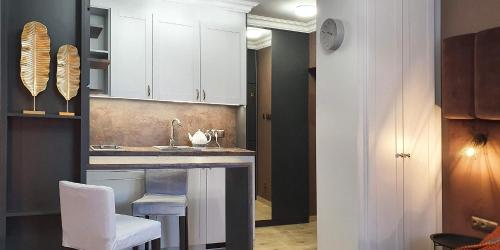 a kitchen with white cabinets and a sink and stool at DK Premium przy Parku Centralnym in Olsztyn