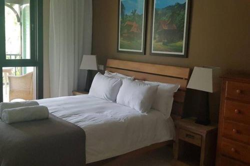 a bedroom with a bed with white sheets and pillows at Maison Bigorno by Simply-Seychelles in Eden Island
