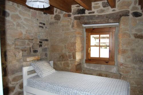 Tempat tidur dalam kamar di Casa Rural El Entamáu