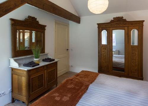 a bedroom with a bed with a dresser and a mirror at inn Venlo Apartment in Venlo