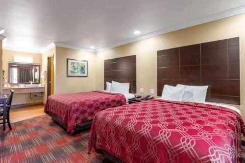 Habitación de hotel con 2 camas con colchas rojas en Econo Lodge Inn & Suites Escondido Downtown en Escondido