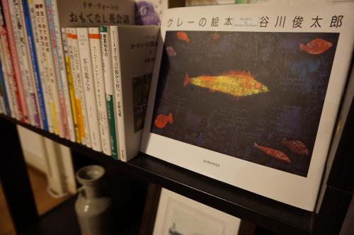 a book shelf with books and a picture of a fish at Guesthouse Ten-roku - Female Only in Osaka