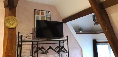 a flat screen tv sitting on a shelf in a living room at LE CHALET SUISSE - Chambre papillons in Le Vicel
