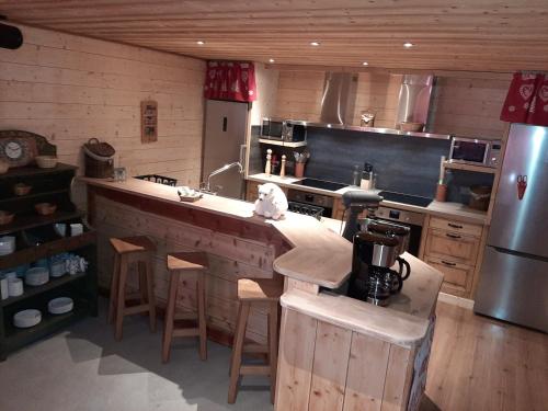 a kitchen with a large counter with stools in it at L'Ours Blanc in La Féclaz