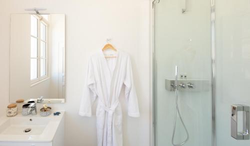 a white robe hanging in a bathroom with a shower at Le Rempart du Midi in Angoulême
