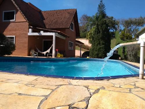uma piscina com uma fonte de água em Alugo linda casa de campo perto de São Paulo com ótimo jardim, piscina e lareira. em Sará-Sará