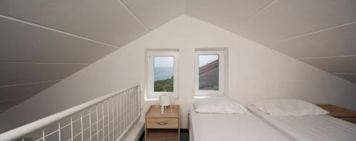 a white room with two beds and a window at Apartments Hostin Garoful Duga Uvala in Krnica