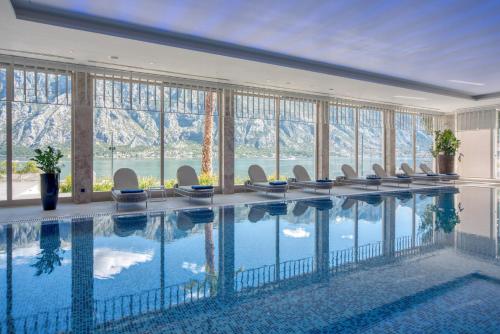 a hotel swimming pool with chairs and a view of mountains at Hyatt Regency Kotor Bay Resort in Kotor
