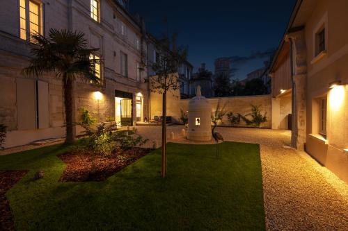 a courtyard of a building at night with a tree in the yard at Le Rempart du Midi in Angoulême