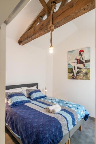 une chambre avec un lit avec une couette bleue dans l'établissement Rosappart, le Paradis ultime, à Les Sables-dʼOlonne