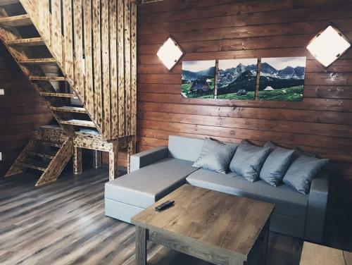 a living room with a couch and a table at Chata Kemp in Tatranska Strba