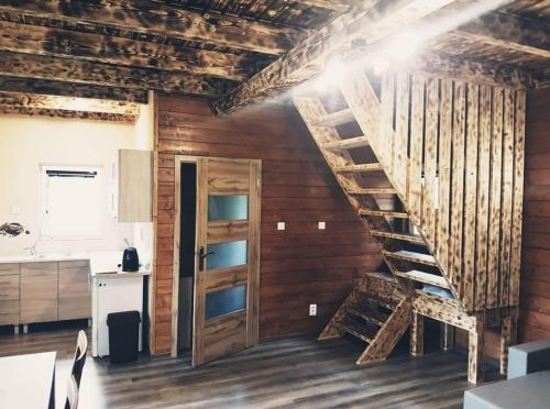 a wooden room with a wooden staircase and a kitchen at Chata Kemp in Tatranska Strba